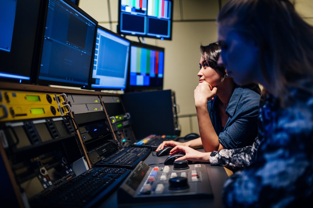 People looking at screens controlling a broadcast.